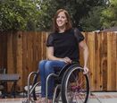 Katherine Beattie sits in her wheelchair and smiles.