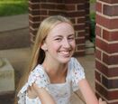 Sarah Todd Hammer smiles as she sits with her arms crossed. 
