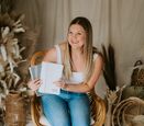 Sommer Fox sits on a chair while showcasing her Discreet Journals.