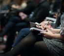 a close up of people taking notes in their notebook at a conference