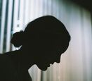 a shadow figure of a woman's face looking down at the floor