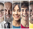 A close-up photo of 7 people of different sexes, ages, and ethnicities, all smiling side by side.