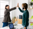 Two work colleagues high five one another.